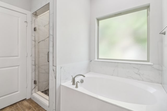 bathroom featuring shower with separate bathtub and hardwood / wood-style floors