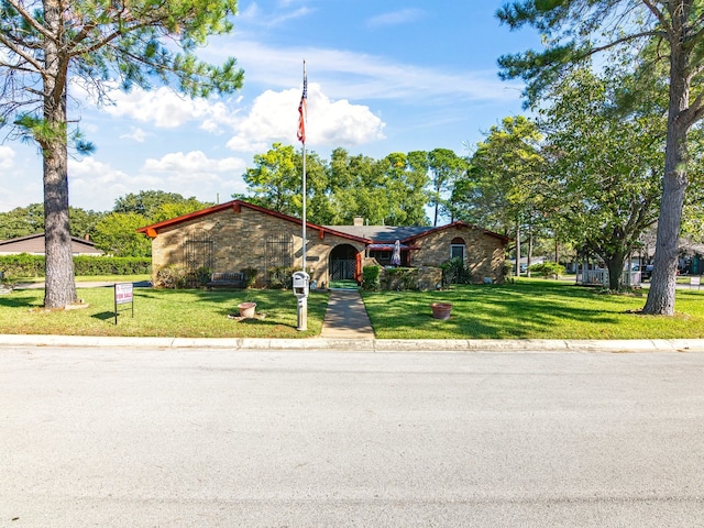 single story home featuring a front lawn