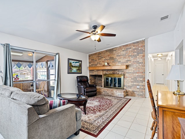 tiled living room featuring vaulted ceiling, ceiling fan, brick wall, and a fireplace