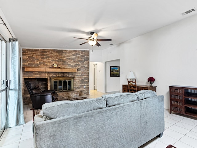 living room with ceiling fan, a fireplace, and light tile patterned floors