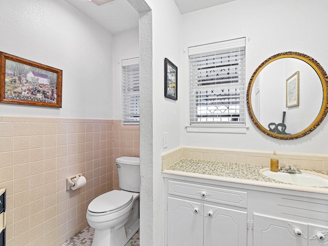 bathroom with vanity, tile walls, toilet, and tile patterned floors