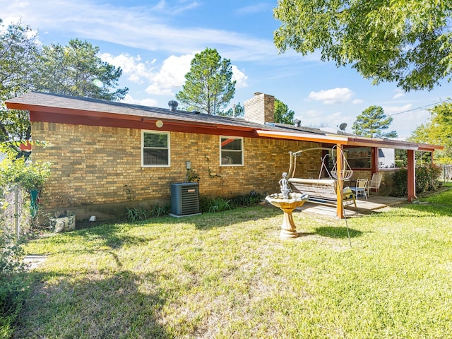 back of property featuring cooling unit, a patio area, and a yard