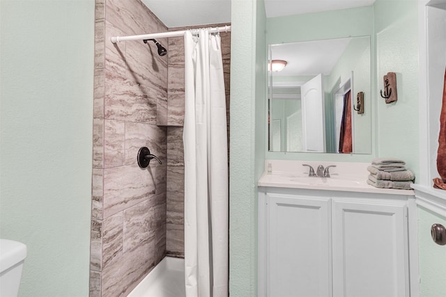 bathroom featuring toilet, vanity, and walk in shower