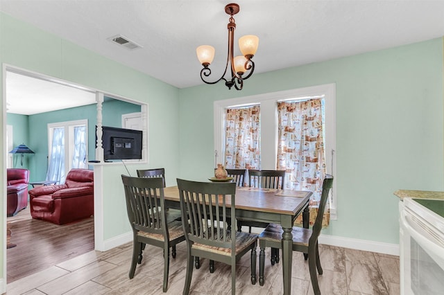 dining room with light hardwood / wood-style floors and a chandelier