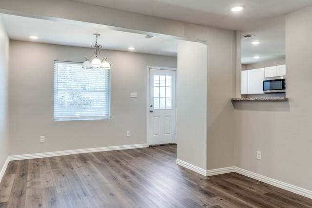 entrance foyer with hardwood / wood-style floors and a chandelier