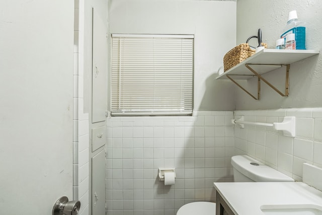 bathroom featuring tile walls, vanity, and toilet