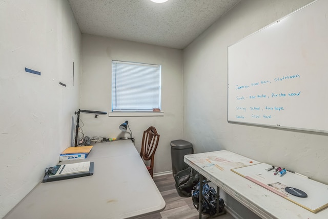 office area featuring light wood-type flooring and a textured ceiling