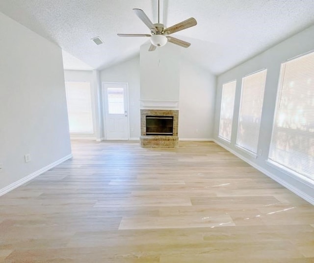 unfurnished living room with ceiling fan, light hardwood / wood-style flooring, lofted ceiling, and a wealth of natural light