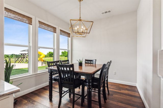 dining room featuring a healthy amount of sunlight, dark hardwood / wood-style flooring, and a notable chandelier