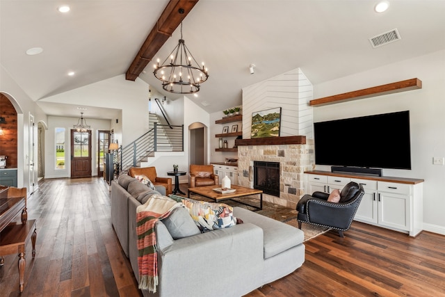 living room featuring high vaulted ceiling, a stone fireplace, beam ceiling, dark hardwood / wood-style floors, and a chandelier