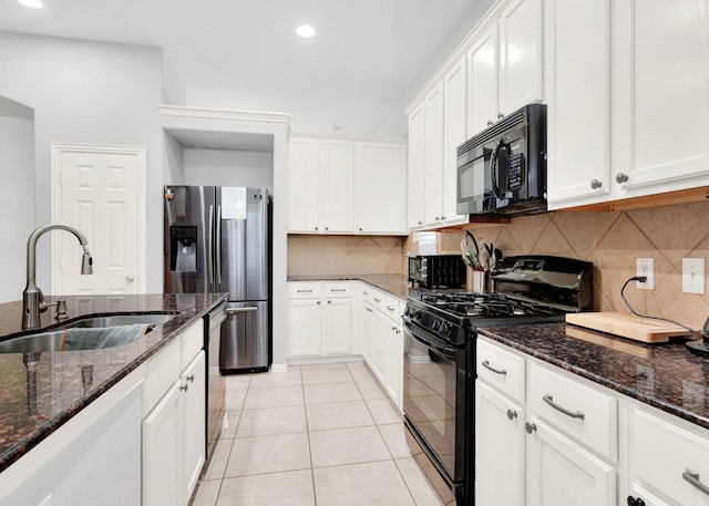 kitchen with dark stone countertops, white cabinets, sink, and black appliances