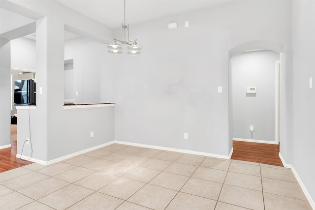 empty room with an inviting chandelier and light wood-type flooring