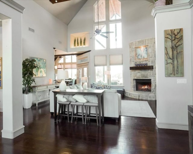 interior space with a high ceiling, a fireplace, dark hardwood / wood-style floors, and ceiling fan