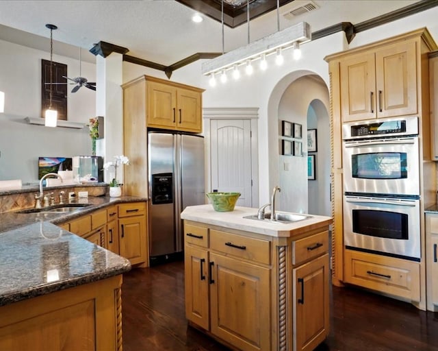 kitchen with ceiling fan, sink, decorative light fixtures, stainless steel appliances, and dark hardwood / wood-style flooring