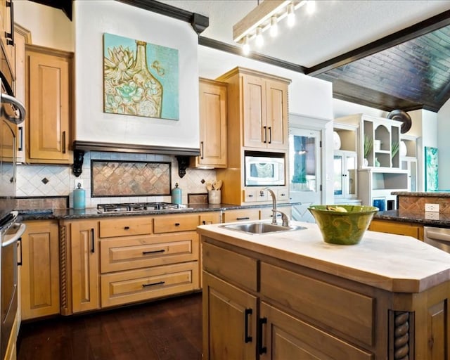 kitchen with an island with sink, backsplash, white microwave, dark hardwood / wood-style floors, and sink