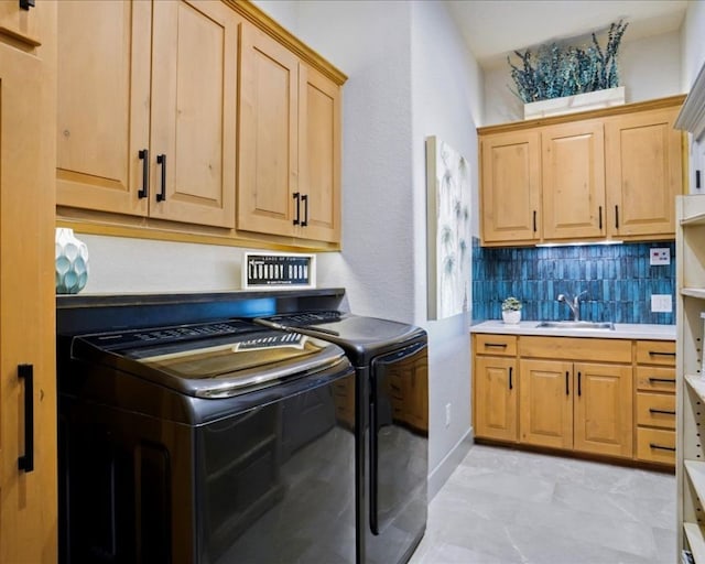 washroom with washing machine and clothes dryer, cabinets, light tile patterned floors, and sink