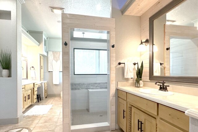 bathroom with vanity, a tile shower, and a textured ceiling