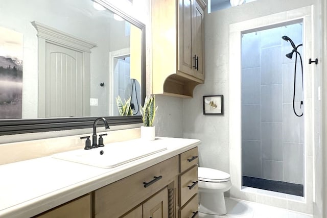 bathroom with toilet, vanity, and tiled shower