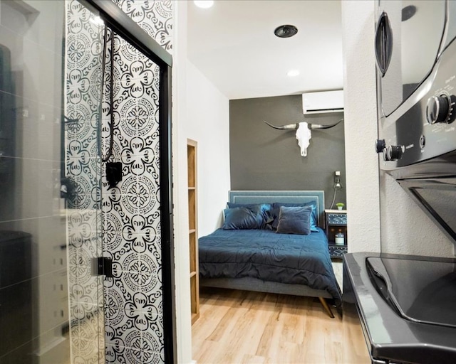 bedroom featuring a wall mounted air conditioner and hardwood / wood-style floors