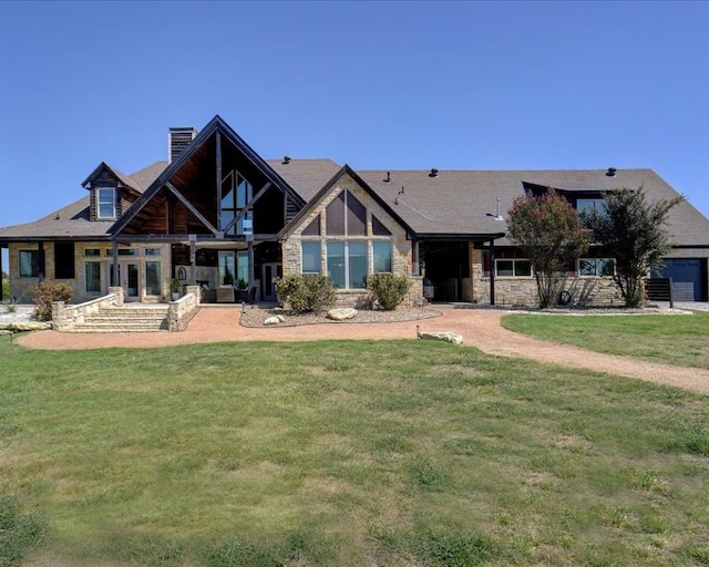 rear view of property featuring a garage and a yard