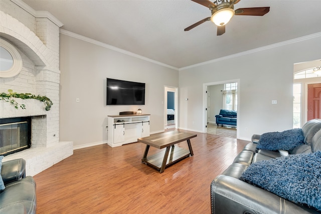 living room with ceiling fan, ornamental molding, a textured ceiling, hardwood / wood-style flooring, and a fireplace