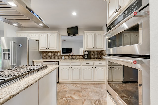 kitchen with white cabinets, appliances with stainless steel finishes, exhaust hood, and tasteful backsplash