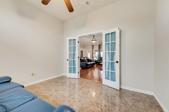 living room featuring light wood-type flooring, ceiling fan, and french doors