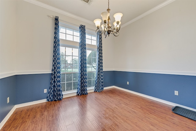 unfurnished room featuring ornamental molding, hardwood / wood-style floors, and a notable chandelier