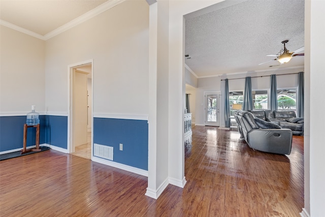 interior space featuring wood-type flooring, a textured ceiling, and crown molding