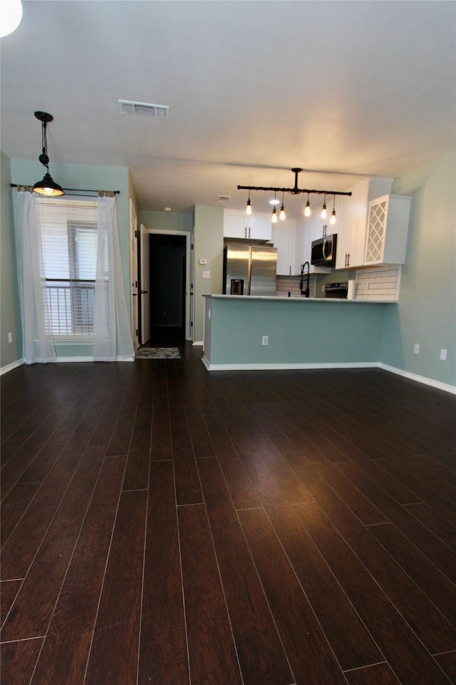 unfurnished living room featuring sink and dark hardwood / wood-style flooring