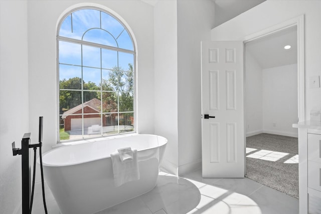 bathroom featuring a healthy amount of sunlight and a tub to relax in