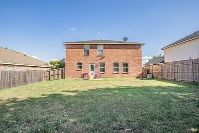 rear view of property with central AC and a yard