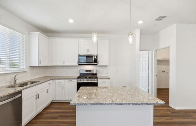 kitchen featuring white cabinets, hanging light fixtures, sink, dark wood-type flooring, and appliances with stainless steel finishes