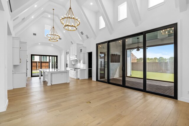 dining room with built in shelves, light wood-type flooring, a tiled fireplace, and plenty of natural light