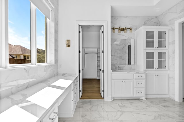 bathroom featuring vanity and tile walls