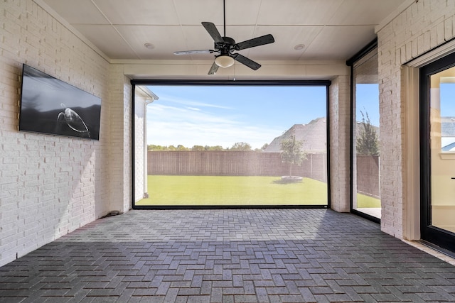 unfurnished sunroom featuring ceiling fan