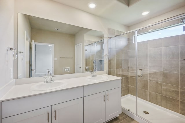 bathroom featuring walk in shower and vanity