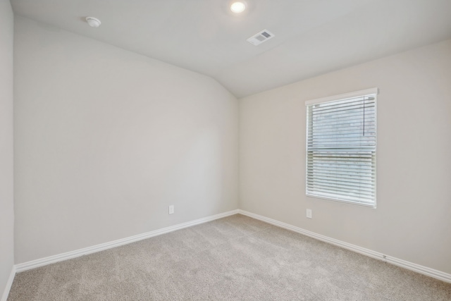 unfurnished room featuring light carpet and lofted ceiling