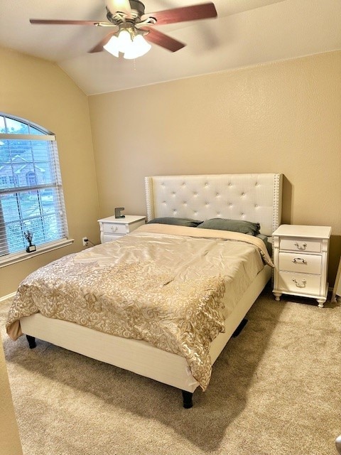 carpeted bedroom featuring vaulted ceiling and ceiling fan