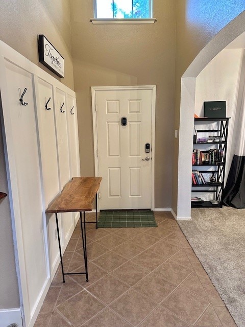 mudroom featuring lofted ceiling and tile patterned flooring