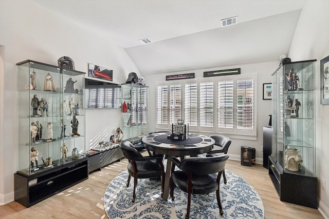 dining area with vaulted ceiling and light hardwood / wood-style flooring