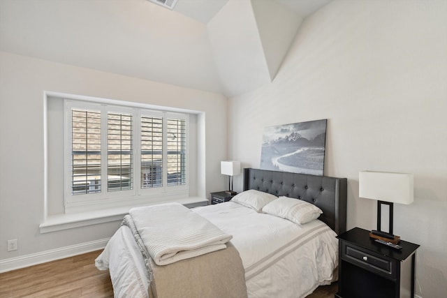 bedroom featuring wood-type flooring and lofted ceiling