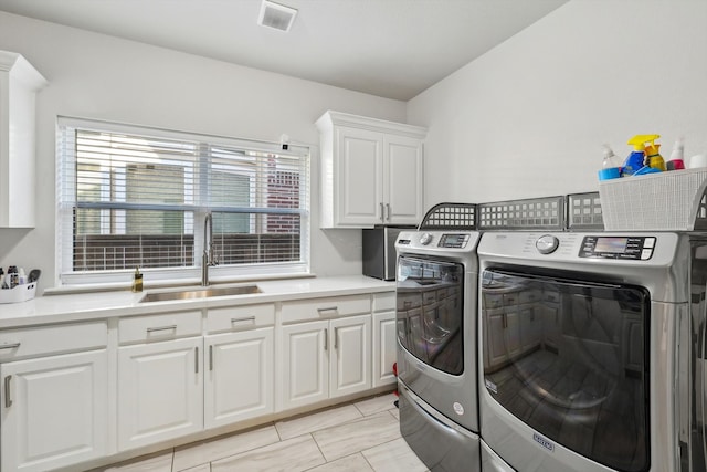 laundry room featuring cabinets, separate washer and dryer, and sink