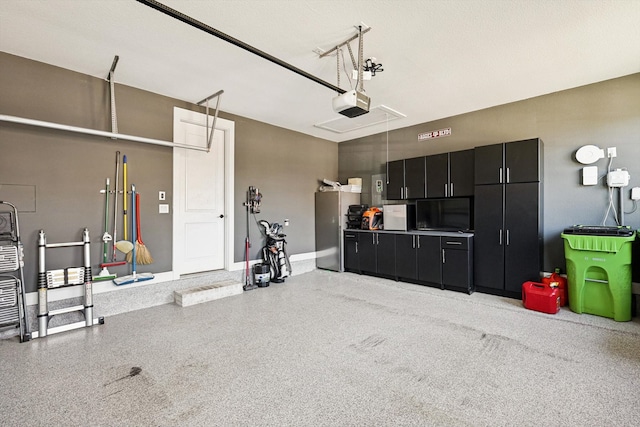 garage featuring a garage door opener and stainless steel fridge