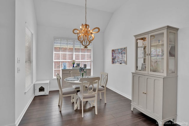 dining room with a notable chandelier, dark wood-type flooring, and vaulted ceiling