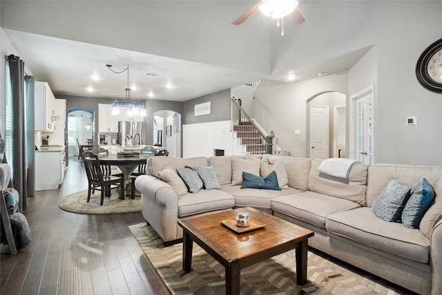 living room with ceiling fan with notable chandelier and wood-type flooring