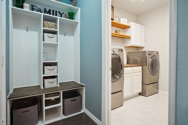 clothes washing area featuring independent washer and dryer and cabinets