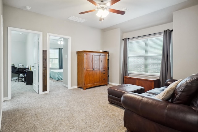 living area with ceiling fan and light carpet