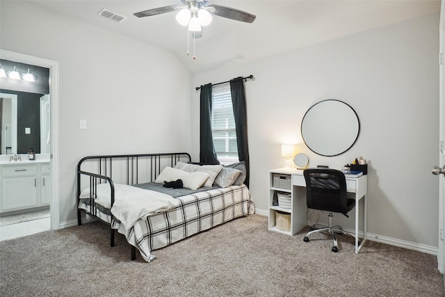 carpeted bedroom featuring ceiling fan, lofted ceiling, ensuite bath, and sink