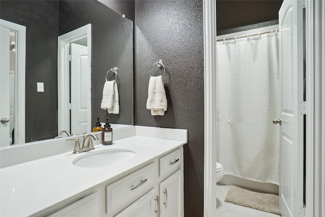 bathroom featuring tile patterned flooring, walk in shower, vanity, and toilet